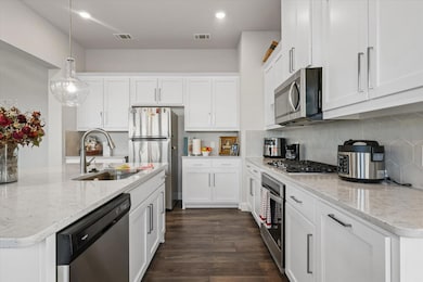 Kitchen featuring pendant lighting, sink, applianc