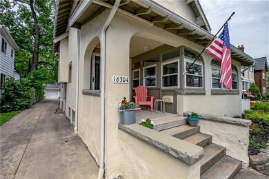 Front porch and paved driveway leading to 3-car garage
