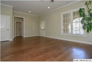 Large den with hardwood flooring and plenty of nat