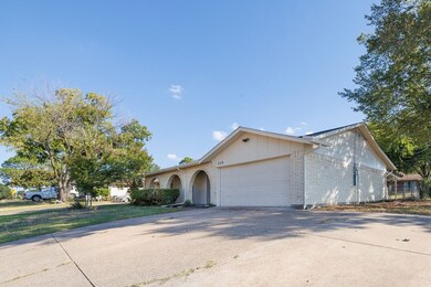 View of front of house featuring brick siding, concrete driveway, and an attached garage