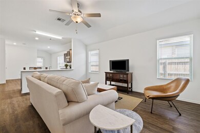 Living room with ceiling fan, dark wood-style flo