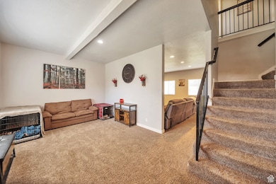 Living room featuring stairway, carpet floors, recessed lighting, and beam ceiling