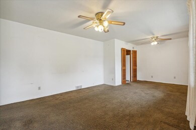 Carpeted spare room featuring ceiling fan