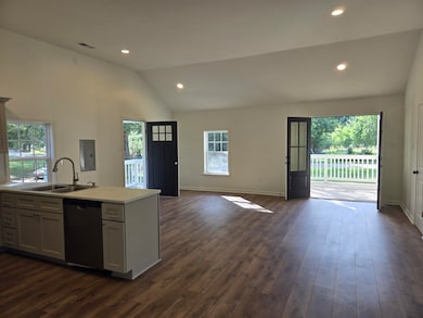 Kitchen with recessed lighting, open floor plan, dark wood finished floors, dishwasher, and vaulted ceiling
