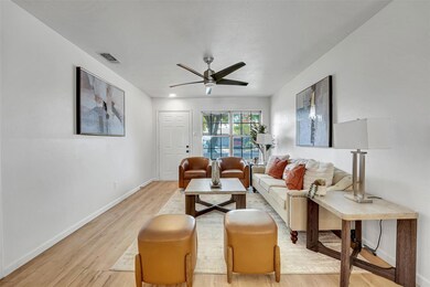 Living room with ceiling fan and light wood-type f