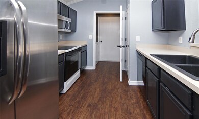 Kitchen featuring dark wood-type flooring, stainle