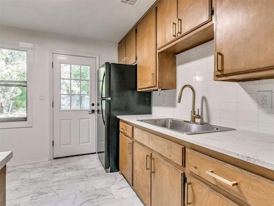 Kitchen with a sink, decorative backsplash, marble