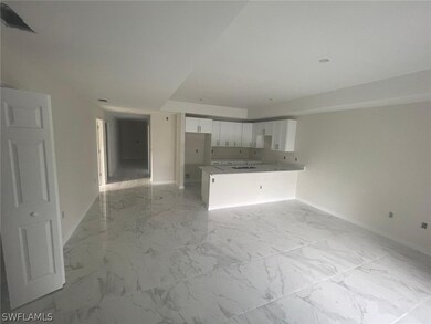 Unfurnished living room featuring sink and light tile floors