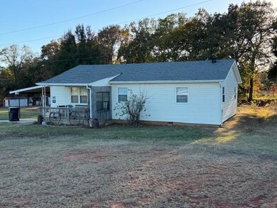 View of front of house with a front lawn and a car
