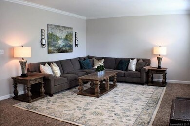 Great room with fireplace and carpet.