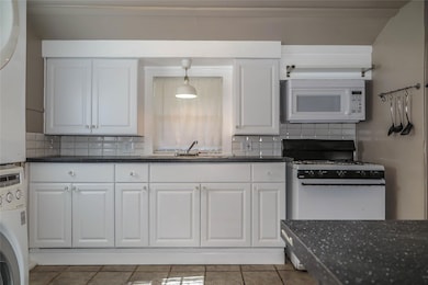 Kitchen featuring white appliances, stacked washe