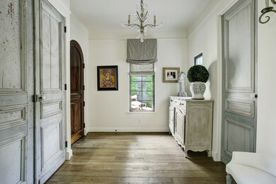 Arched entryways give a gracious yet elegant feel to the home. A beautiful antique set of doors adorn the space, opening to a spacious coat closet.  The powder room has been renovated to include antique finishes from Chateau Domingue.
