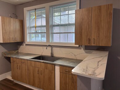 Kitchen with dark wood-style flooring and light countertops
