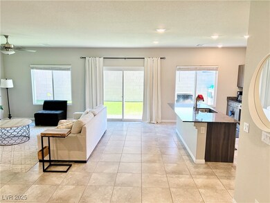 Living area featuring a ceiling fan, light tile pa