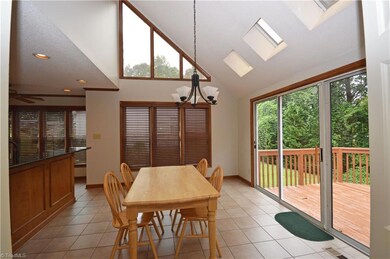 Breakfast room with vaulted ceiling, skylights and door to deck. Surrounded by natural light!!
