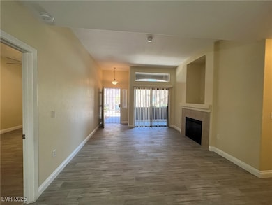 Unfurnished living room with wood finished floors and a tile fireplace
