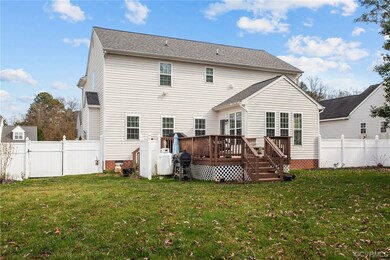 Back of property featuring a wooden deck and a lawn
