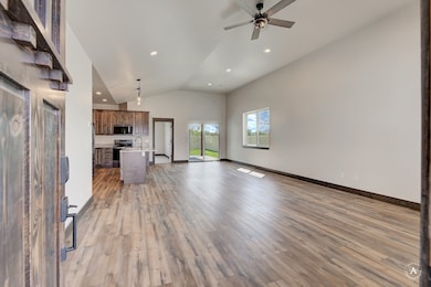 Unfurnished living room featuring light wood finished floors, high vaulted ceiling, ceiling fan, and recessed lighting