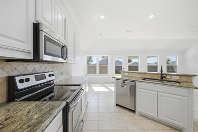 Kitchen with stainless steel appliances, white cabinetry, tasteful backsplash, dark stone countertops, and recessed lighting
