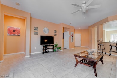 Living area with baseboards, a ceiling fan, and li