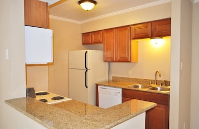 Kitchen with ornamental molding, white appliances,