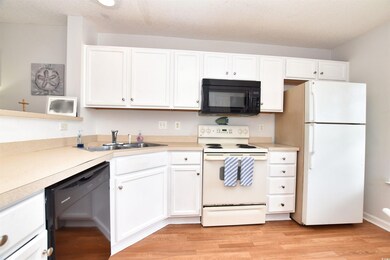 Kitchen with light wood-type flooring, black appli