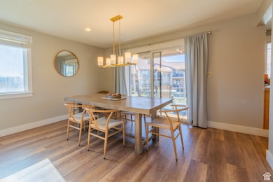 Dining space featuring plenty of natural light, light wood-style floors, a chandelier, and recessed lighting