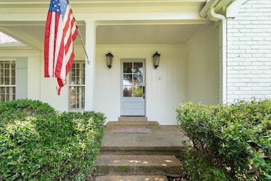 Doorway to property with brick siding and a porch