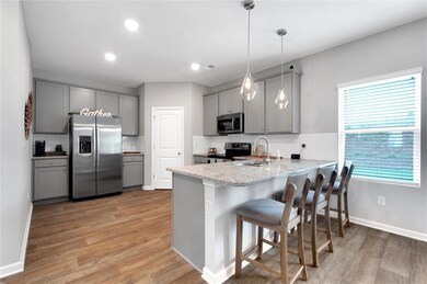 Kitchen with tasteful backsplash, gray cabinets, a