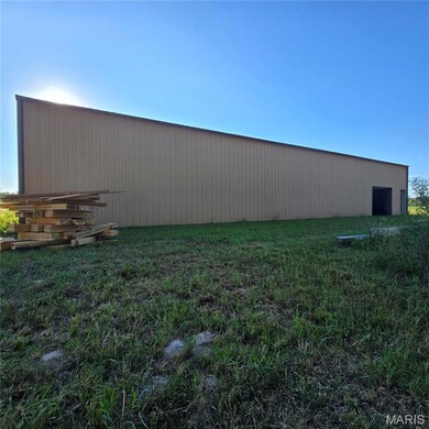 View of green lawn with a pole building and an outbuilding