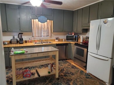 Kitchen with light tile patterned floors, a sink, 