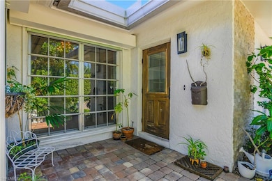 Property entrance with stucco siding and a patio area