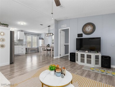 Living room featuring ceiling fan, light hardwood