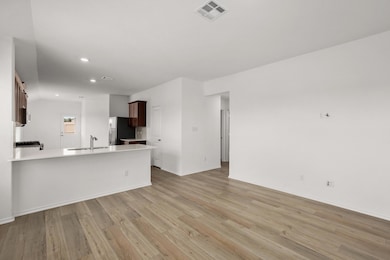 Unfurnished living room featuring a sink, light w