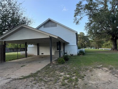 View of home's exterior featuring a lawn and a car