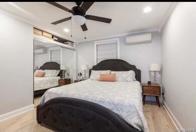 Bedroom featuring light wood-type flooring, recessed lighting, a wall mounted air conditioner, a ceiling fan, and an AC wall unit