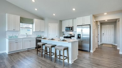 The Finnegan's open concept main level features a spacious kitchen with center island.  Photos of model home. Colors and options may vary. Ask Sales Agent for details.