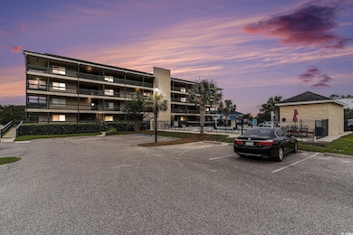 View of building exterior featuring uncovered parking