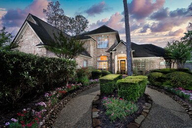 The front yard boasts a meticulously manicured lawn, vibrant flower beds, and neatly trimmed bushes, creating a lush and inviting atmosphere. A pathway of carefully laid stones leads to the elegant entrance, flanked by shrubbery that provide shade and privacy.