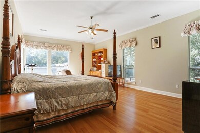 Bright, airy master bedroom with wood floors and c