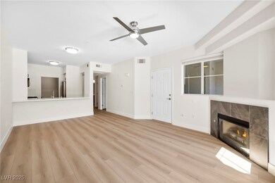 living room featuring brand new light wood-style floors, a tile fireplace, and ceiling fan