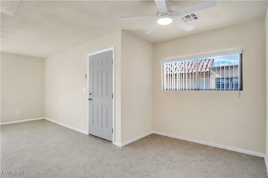 Spare room with ceiling fan, visible vents, and ba