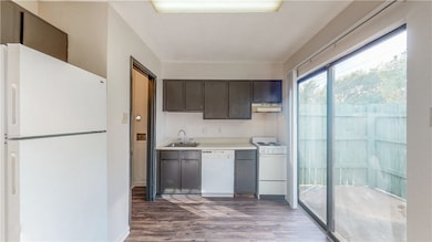 Kitchen with wood finished floors, a sink, light c