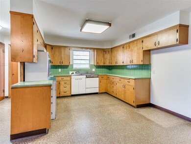 Kitchen with white appliances, tasteful backsplash