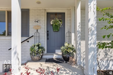 Property entrance featuring brick siding and covered porch