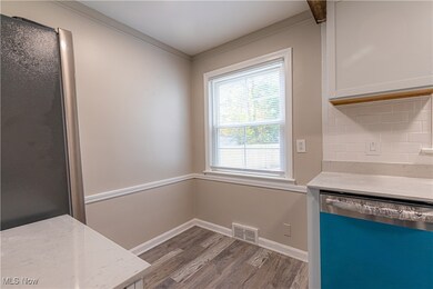 Unfurnished dining area with light wood-style flooring and ornamental molding