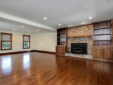 Great Room. View of built in bookcases and wood mantle above fireplace