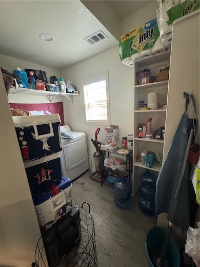 Laundry room with washer / dryer, dark wood-style floors, and a textured ceiling