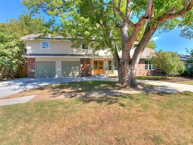 Front of home, featuring circle drive, mature tree