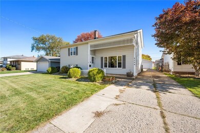 View of front facade featuring a chimney, a front lawn, a garage, and an outdoor structure